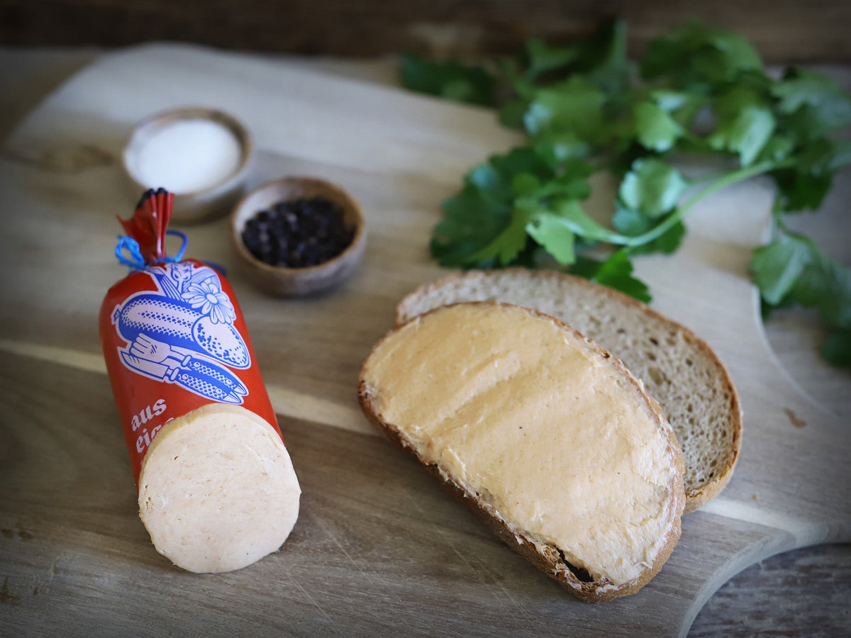 Das Bild zeigt Land.Luft Bio Teewurst, eine feine Mettwurst, serviert auf einer Brotscheibe. Die hochwertige Wurstspezialität eignet sich perfekt für Brotzeit, Brötchen, Snacks oder als delikater Aufstrich für Feinschmecker