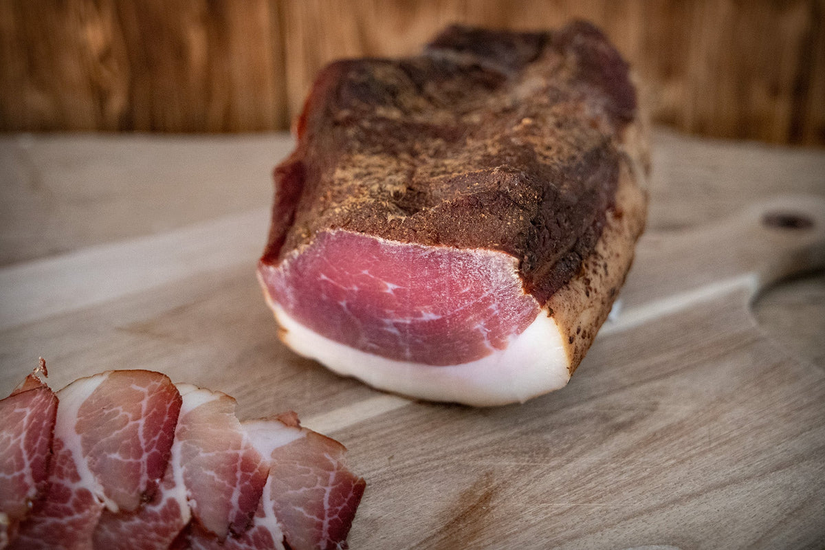 Auf dem Bild ist ein Bio Bauerngeräucherter Schlegel von Land.Luft zu sehen – aromatisch geräuchert und ideal für Brotzeit, Wurstplatten oder herzhafte Mahlzeiten.