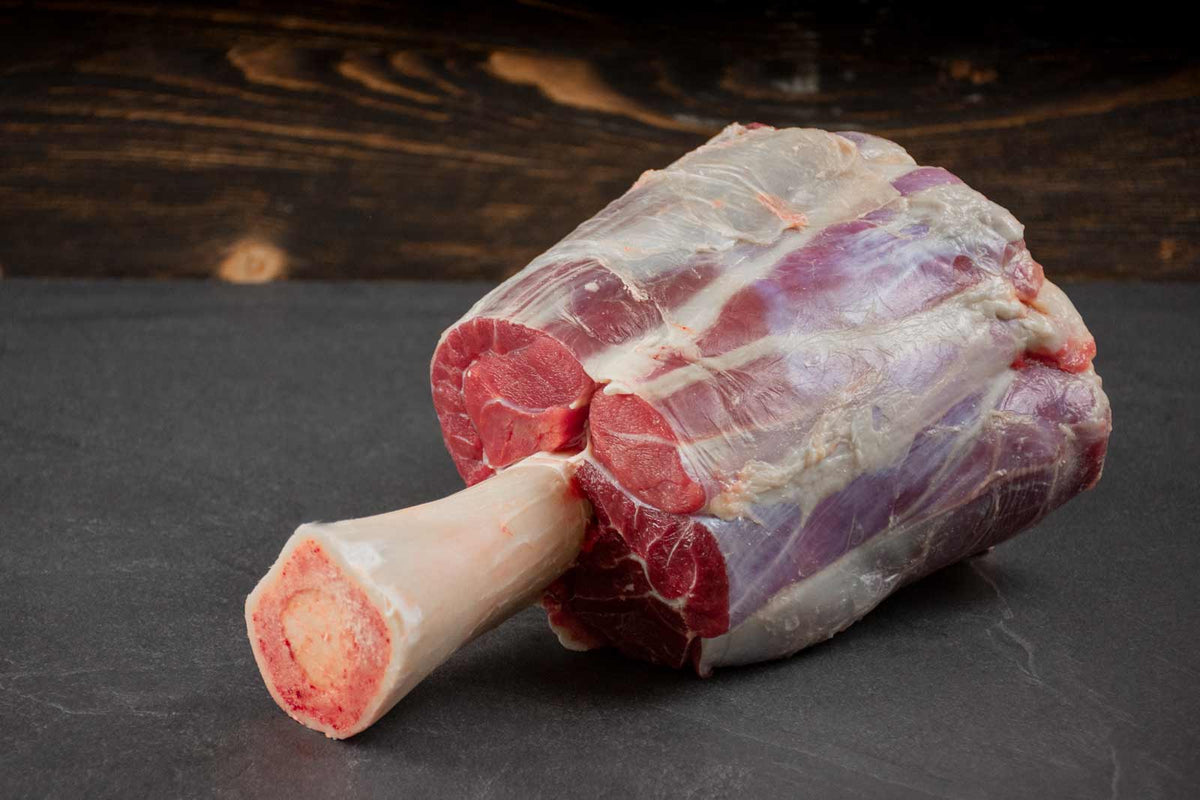 Auf dem Bild ist Bio Angus Beef Hammer zu sehen – ein Teilstück aus dem Rinderbein am Knochen. Zart, aromatisch und ideal zum Schmoren, Braten oder für kräftige Eintöpfe