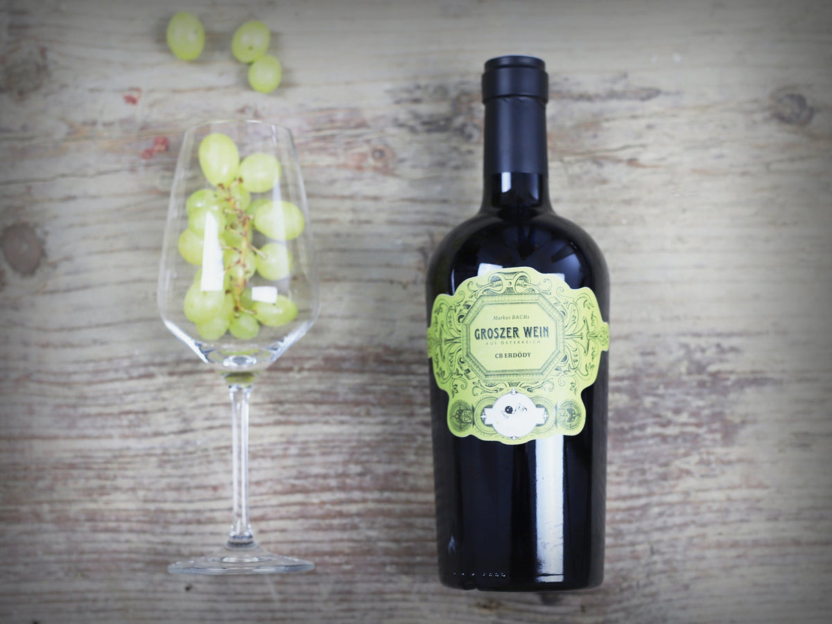 Das Bild zeigt eine Flasche Groszer Wein Csaterberg Erdödy neben einem dekorativen Weinglas mit grünen Trauben. Die elegante Präsentation unterstreicht die Qualität des Weins und eignet sich ideal für Genießer, besondere Anlässe oder als Geschenk