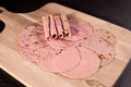Auf dem Bild ist eine Auswahl gemischter Aufschnittwurst in Bio-Qualität zu sehen, darunter Lyoner, Paprikalyoner, Jagdwurst und Bierschinken. Alle aufgeschnitten und bereit für Brotzeit oder Wurstplatten.