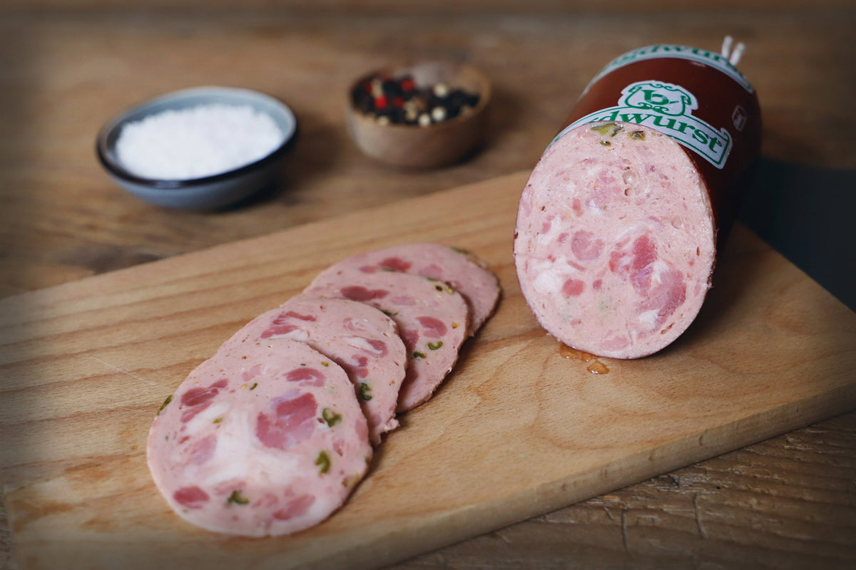 Auf dem Bild sind kleine Portionen Fleischwurst mit Schinkeneinlage zu sehen – aromatisch, saftig und ideal für Brotzeit, Wurstplatten oder als herzhafter Snack.