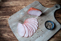 Das Bild zeigt Kaiserfleisch, gegart und mild geräuchert – ein kalorienarmer Schinken aus der Lende und dem Rücken. Die hochwertige Spezialität eignet sich perfekt für Brotzeit, Wurstplatten, Sandwiches oder als delikater Snack für Feinschmecker.