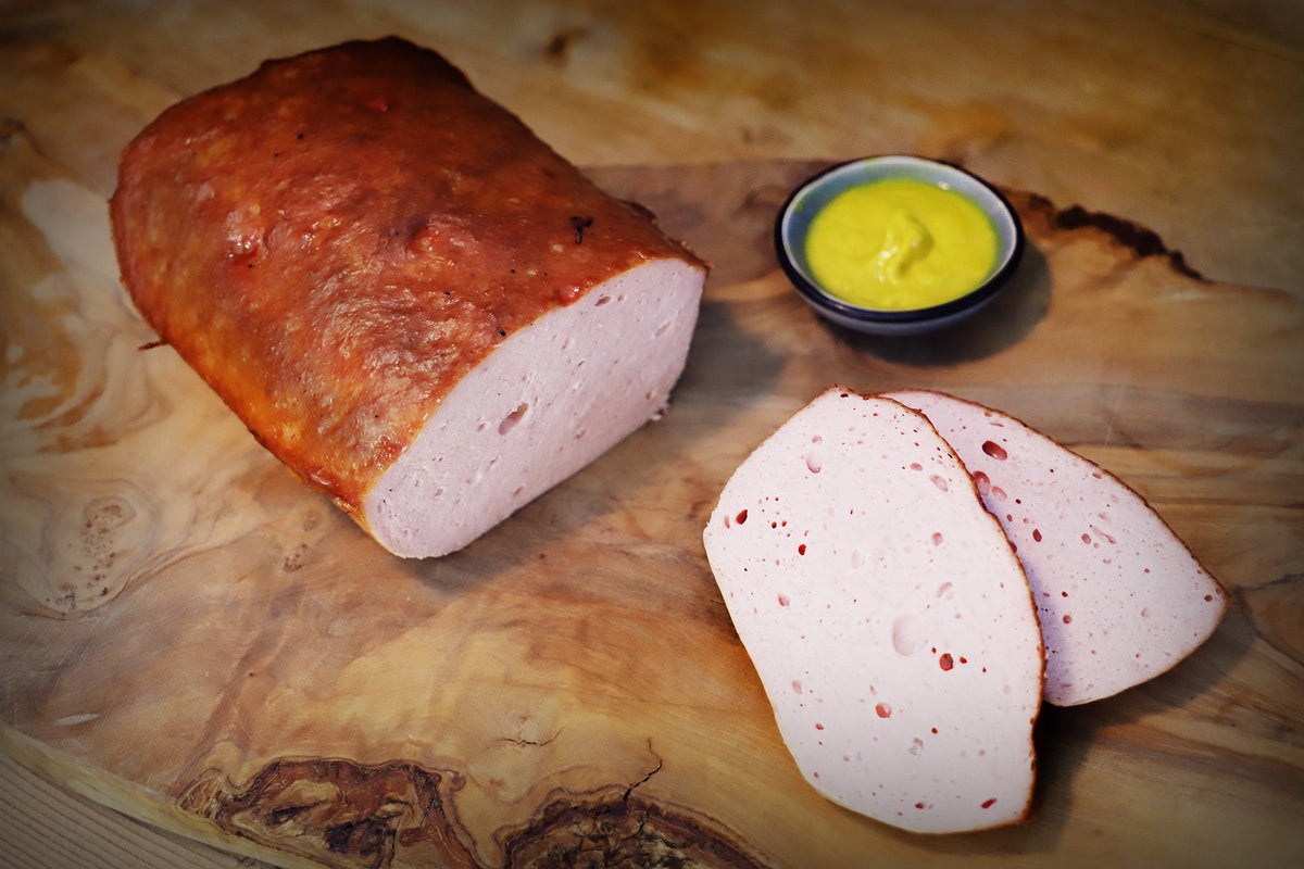 Auf dem Bild ist Bio-Leberkäse zu sehen, vorgebacken und am Stück – ideal zum Schneiden für Brotzeit, Brötchen oder herzhafte Mahlzeiten