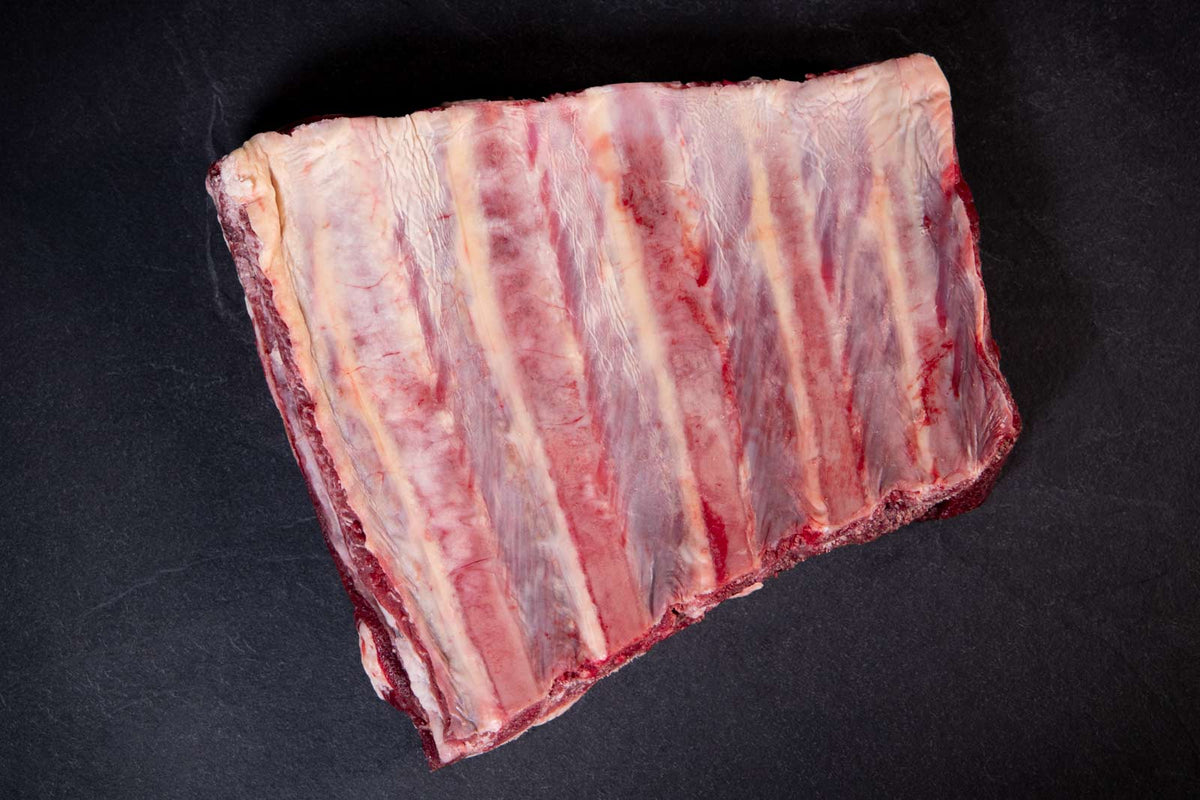 Das Bild zeigt Angus Rinderrippchen (Back Ribs, Angus Beef Ribs). Die hochwertigen Rippchen eignen sich perfekt zum Grillen, Schmoren oder für herzhafte BBQ-Gerichte. Zartes Fleisch mit intensivem Geschmack, ideal für Feinschmecker und Grillliebhaber